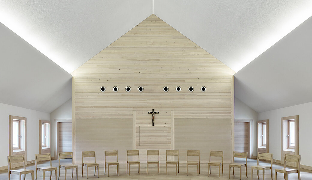 Tagungsraum mit Stuhlhalbkreis und Wandkreuz