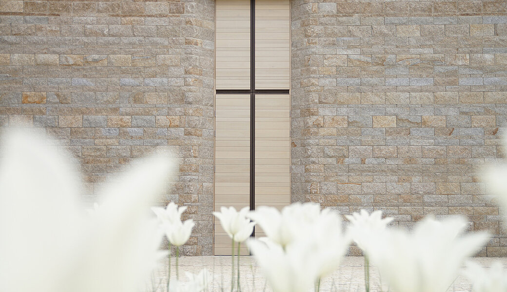 Eingangstür Kapelle Haus Johannisthal mit weißen Blumen im Vordergrund
